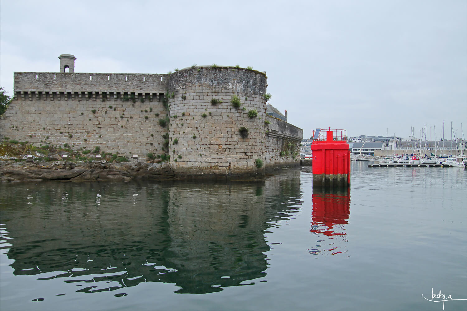 Les tours de la Ville Close de Concarneau, vue du port, contraste à la bouée rouge